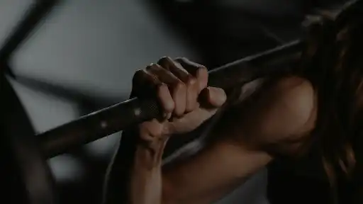 A woman lifting a barbell in a gym